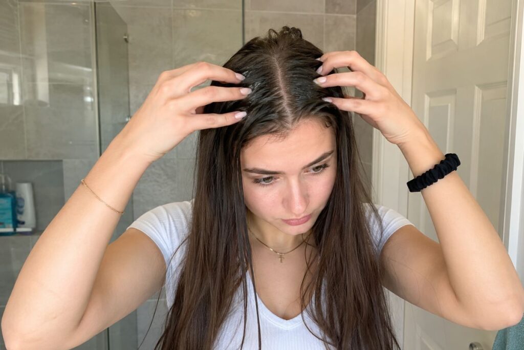 Woman massaging coconut oil into scalp for hair growth
