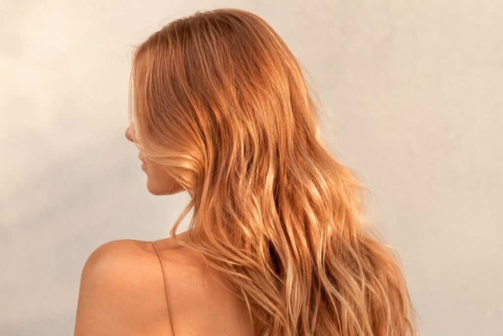 Strawberry blonde hair color level 8 with warm peachy pink tones