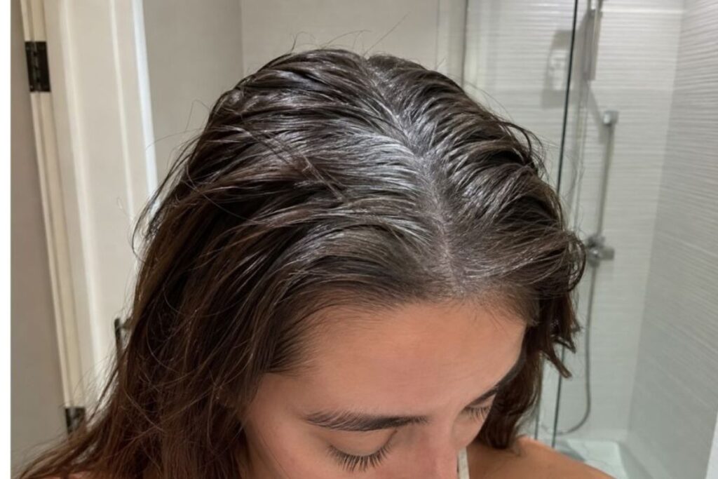 Chalky dry shampoo residue on damp hair roots