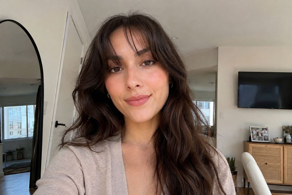 Long waves with curtain bangs for oblong face shape
